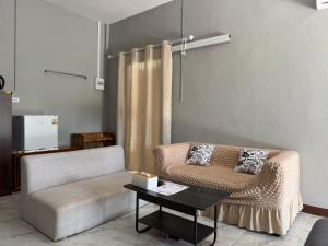 a living room with a couch and a table at Phak Ploen Home Stay in Ban Rae Mai Phai