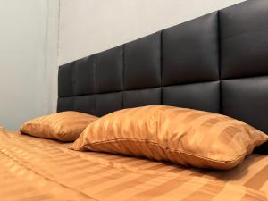 two pillows on a bed with a black headboard at Phak Ploen Home Stay in Ban Rae Mai Phai