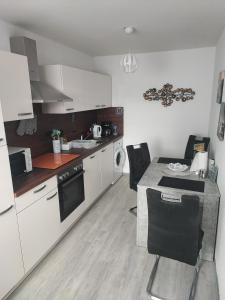 a kitchen with white cabinets and a table with chairs at Sweet Home in Hameln