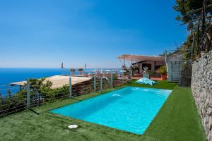 a swimming pool with the ocean in the background at Villa Gioiello in Amalfi