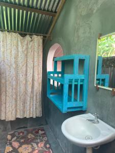 a bathroom with a sink and a blue shelf at Sunflower Cottage near Ojo de Agua in Las Pilas