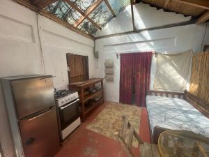 a small kitchen with a stove and a refrigerator at Sunflower Cottage near Ojo de Agua in Las Pilas