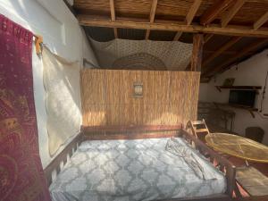 a small bed in a room with a table at Sunflower Cottage near Ojo de Agua in Las Pilas