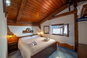 a bedroom with a large bed with a wooden ceiling at Villa Gioiello in Amalfi +59 photos
