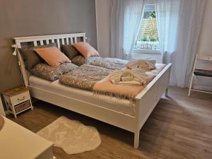 a bedroom with a large bed with pillows and a window at Tohuus - Fewo bei Hamburg in Hasloh