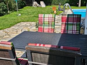 a black table with chairs and a pool at Tohuus - Fewo bei Hamburg in Hasloh +16 photos