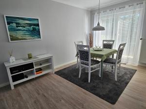 a dining room with a green table and chairs at Tohuus - Fewo bei Hamburg in Hasloh
