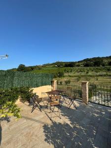 a patio with a table and chairs and a fence at QUEEN appartamenti e camere in Campofilone