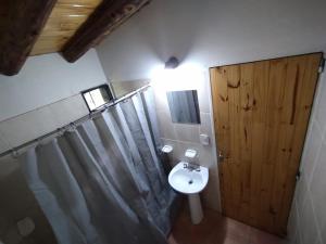 a bathroom with a sink and a wooden door at Antonio House in Uspallata