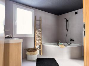 a bathroom with a tub and a window and a sink at Revier beau jardin in Glarus