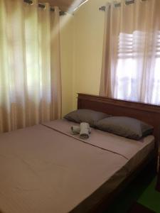 a bedroom with a bed with a window and a pillow at Villa Golden Drift in Ahangama