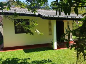 a green house with a window and grass at Villa Golden Drift in Ahangama