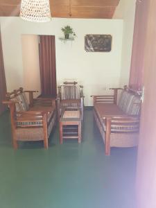 a room with three wooden chairs and a table at Villa Golden Drift in Ahangama