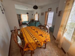 a dining room with a table with a yellow blanket on it at La maison des vacances in Cap Malheureux