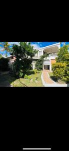 a large white house with trees in front of it at La maison des vacances in Cap Malheureux