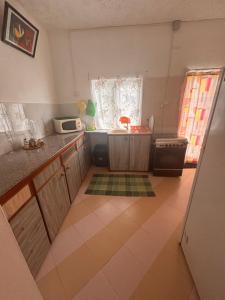 a small kitchen with a sink and a microwave at La maison des vacances in Cap Malheureux +8 photos