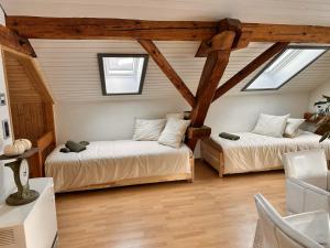 two beds in a room with two windows at Revier belle étage in Glarus