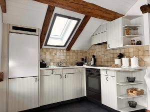 a kitchen with white cabinets and a window at Revier belle étage in Glarus +10 photos