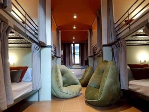 a room with two bunk beds and two chairs at Nitra Hostel Siriraj in Bangkok +15 photos