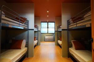 a room with four bunk beds with a hallway at Nitra Hostel Siriraj in Bangkok