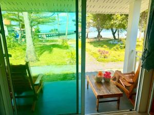 a screened in porch with a table with flowers on it at Kohmook sunrise beach in Ko Muk