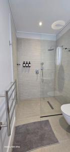a bathroom with a shower with a toilet and a sink at Fynbos N Sea in Gansbaai +21 photos