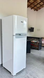 a white refrigerator in a room with a tv at Pousada Cantinho da Mata in Paraty