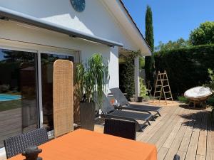 a patio with a table and chairs on a deck at Les Tignoliers in Tignieu-Jameyzieu