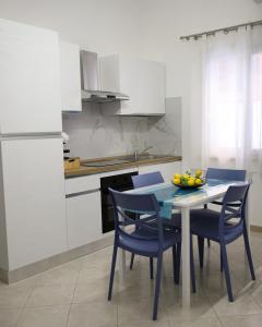 a kitchen with a table with chairs and a bowl of fruit on it at L'arco Sul Mare in Balestrate