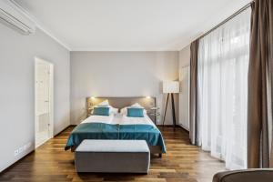 a bedroom with a bed with a blue comforter at GLANDON Rooms Elite in Biel