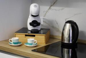 a coffee maker sitting on a counter next to cups at L'arco Sul Mare in Balestrate