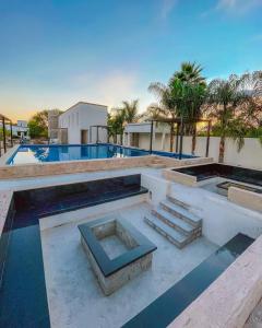 a swimming pool with stairs and a building at Yolihuani Relax Resort in Calvillo