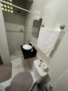 a bathroom with a toilet and a sink and a mirror at Estação 48 in Castanhal +19 photos