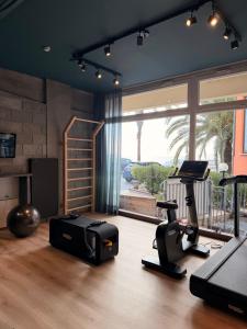a room with a gym with a treadmill elliptical and a window at Hotel Jolly Roger in Pietra Ligure