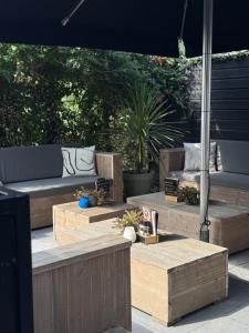 a patio with wooden benches and tables with plants at B&B D'n Optie in Druten
