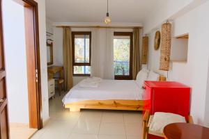 a bedroom with a white bed and a red cabinet at The Place Boutique Hotel Kalkan in Kalkan