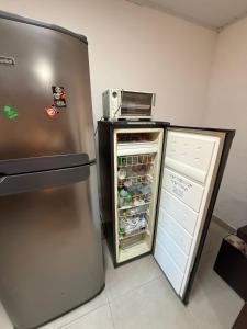 a refrigerator with its door open in a kitchen at Kit net great price in São Sebastião