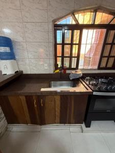 a kitchen with a sink and a stove at Kit net great price in São Sebastião +57 photos
