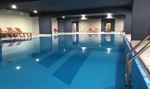 a large swimming pool with blue water in a building at CENTRAL Stars Apartments & Free parking in Vrnjačka Banja