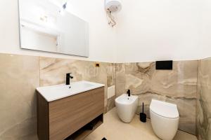 a bathroom with a sink and a toilet at Dimora Due Mari in Salice Salentino +18 photos