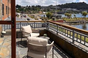 a balcony with chairs and a view of a river at Radisson Hotel Puerto Varas in Puerto Varas