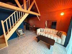a living room with a couch and a staircase at Tiny Chalet in Paluel +1 photo