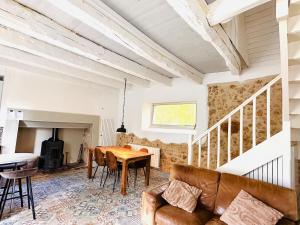 a living room with a table and a couch at Les Deux Canards Perdus in Rouffignac Saint-Cernin