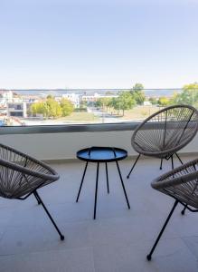 two chairs and a table in front of a window at Peace Home Trikala in Tríkala