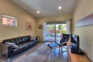 a living room with a leather couch and a tv at The Kayenta Flat in Moab UT in Moab +11 photos