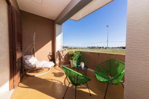 a balcony with two green chairs and a table at Dimora Due Mari in Salice Salentino
