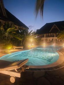 a large swimming pool in a resort at night at Nyota 11 - Jua Resort in Watamu
