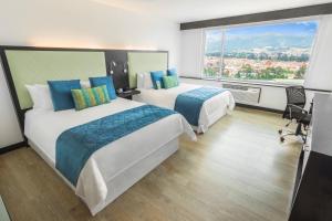 a hotel room with two beds and a large window at Four Points by Sheraton Cuenca in Cuenca +91 photos