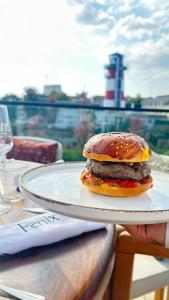 a hamburger sitting on a plate on a table at Hayat Hotels & Apartments in Rust