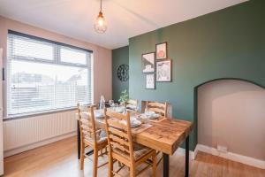 a dining room with a wooden table and chairs at Spacious 3-Bed with parking NEAR NEC & BHX AIRPORT in Allesley +36 photos
